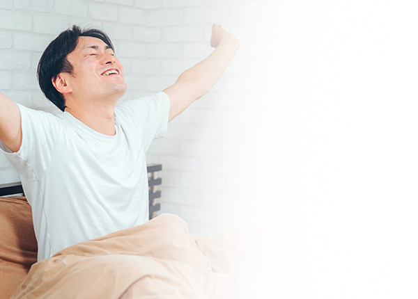 朝起きて伸びをする男性